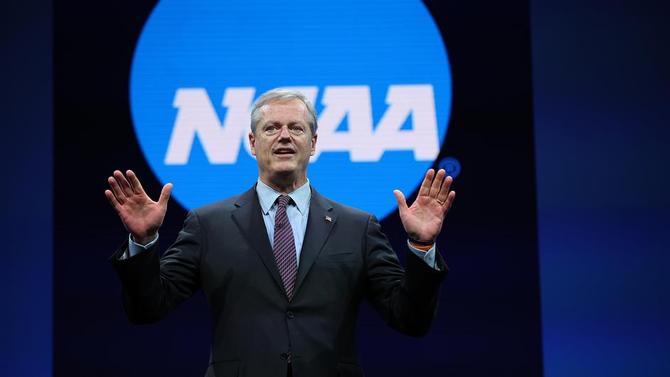 NCAA president Charlie Baker speaks while standing in front of the organization’s logo.
