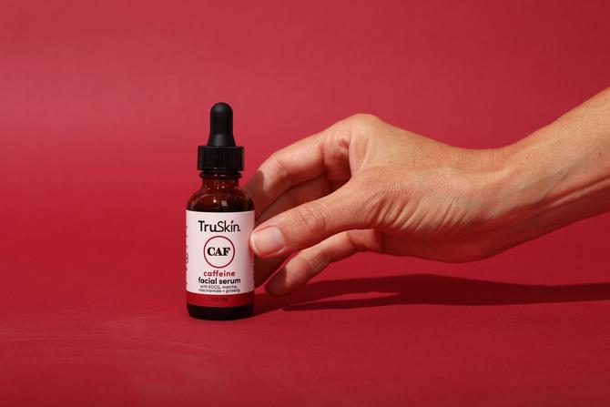 A person holding a bottle of TruSkin serum