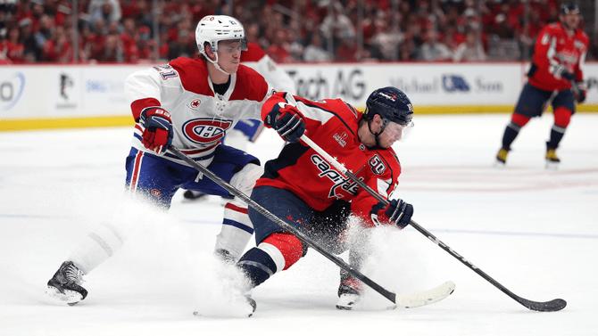 A Montreal Canadiens player goes up against a Washington Capitals player.
