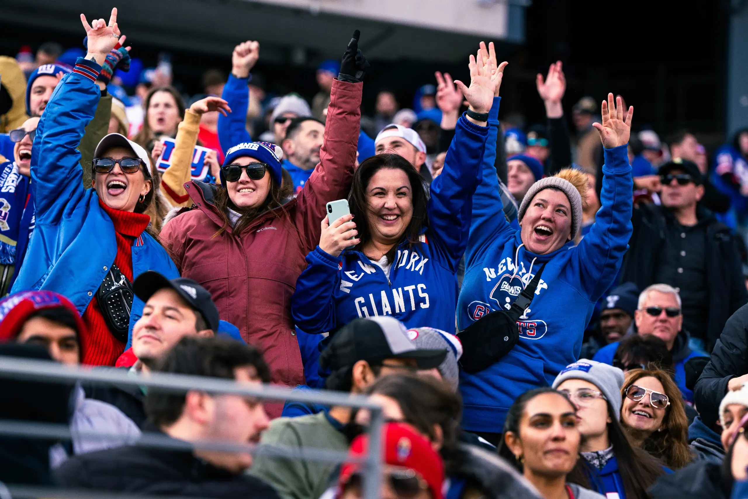 Female NY Giants fans celebrate at a game. 