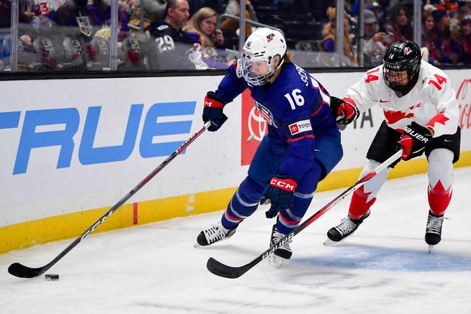 Hayley Scamurra of Team USA and Renata Fast of Team Canada battle for the puck.