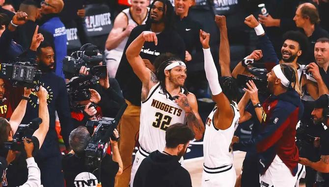 Denver Nugget Aaron Gordon gestures that the basket should be counted as his teammates celebrate around him.