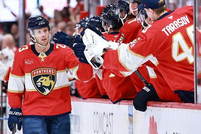 Carter Verhaeghe of the Florida Panthers high fives teammates after scoring a goal.