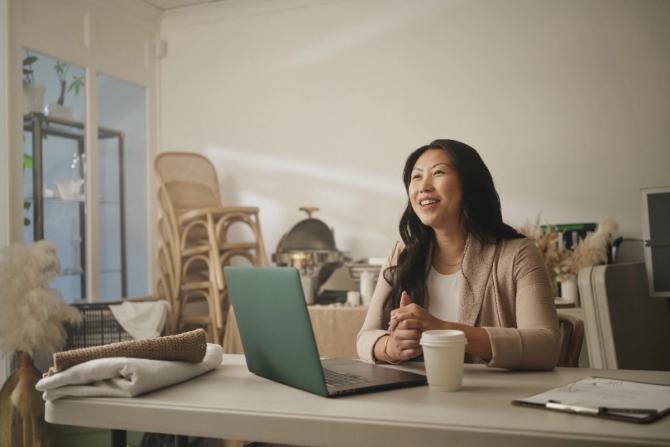 A woman sitting at a desk with her laptop open