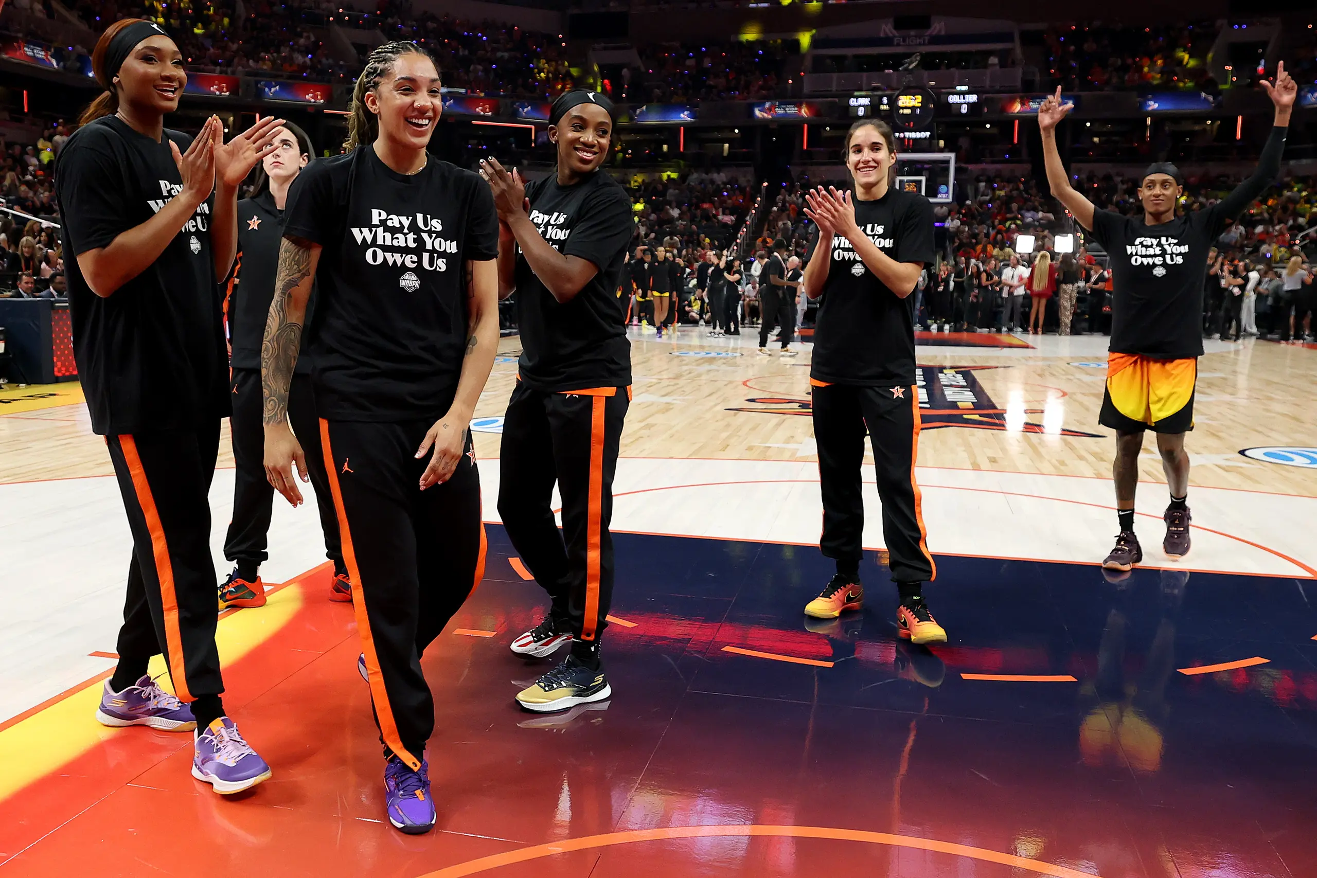 WNBA players wear 'pay us what you owe us' shirts prior to the 2025 All-Star Game.