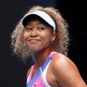 Naomi Osaka smiles on the tennis court.