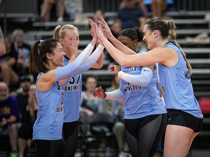 AU Pro Volleyball players celebrate a point. 