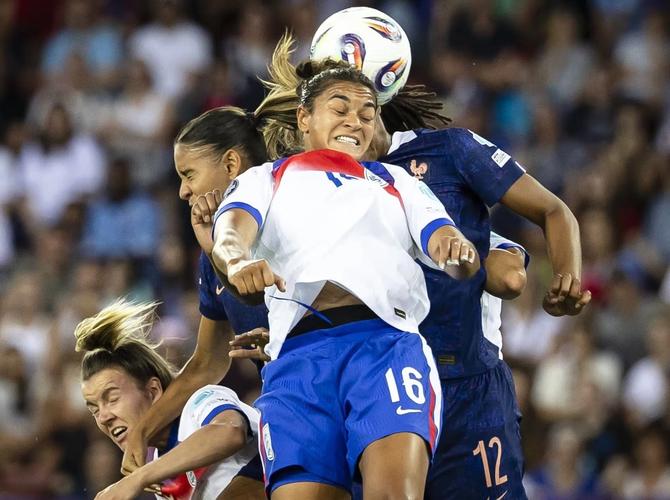 England’s Jess Carter battles for the ball against a pair of French players.