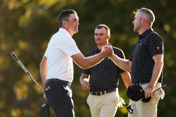 Keegan Bradley of the U.S. Team shakes hands with Taylor Pendrith of Canada and the International Team