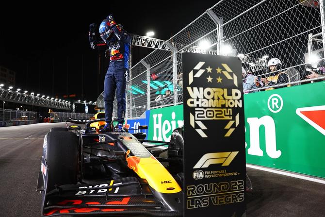 2024 F1 World Drivers Champion Max Verstappen stands on his car in celebration after winning his fourth straight title in Las Vegas.