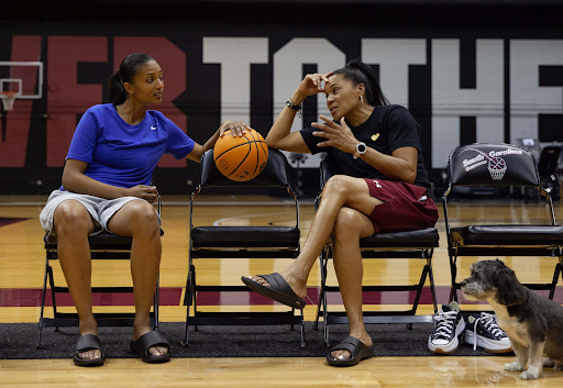 Women’s basketball legend and University of South Carolina women’s basketball head coach Dawn Staley wears Oofos shoes while seated at the university’s basketball court.