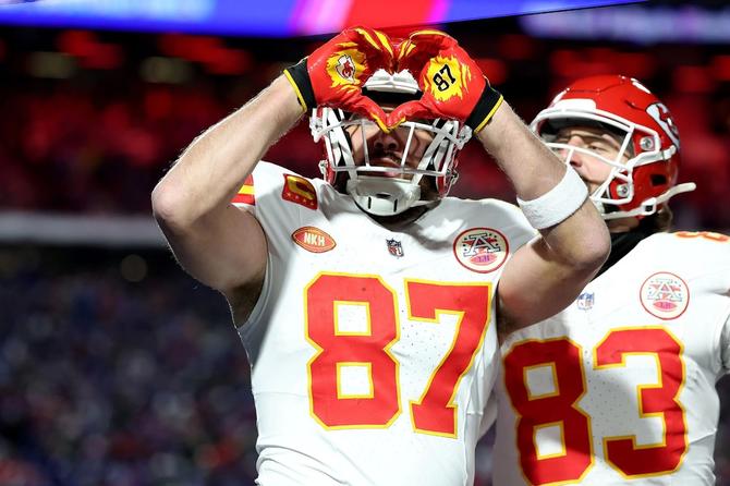 Alt text: Kansas City tight end Travis Kelce holds up his hands in the shape of a heart.