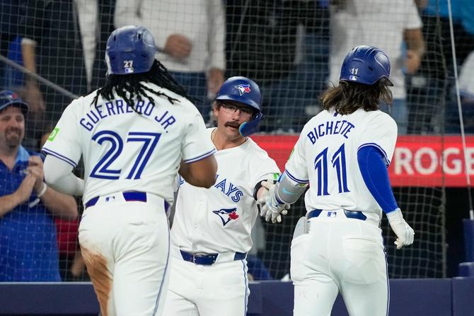 Bo Bichette #11 of the Toronto Blue Jays celebrates with teammates Vladimir Guerrero Jr. #27 and Davis Schneider #36 after hitting a home run against the Seattle Mariners