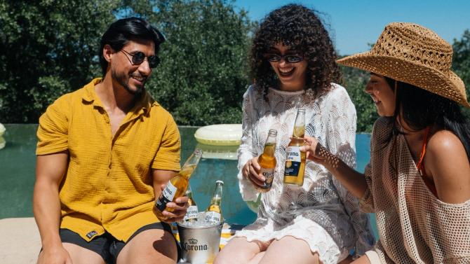 A group of people enjoying bottles of Corona Extra outdoors