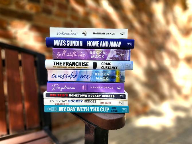 A stack of books perched on a bench