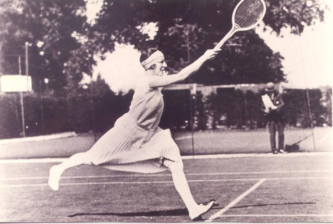 “La Divine” Suzanne Lenglen following through. Photo in black and white.