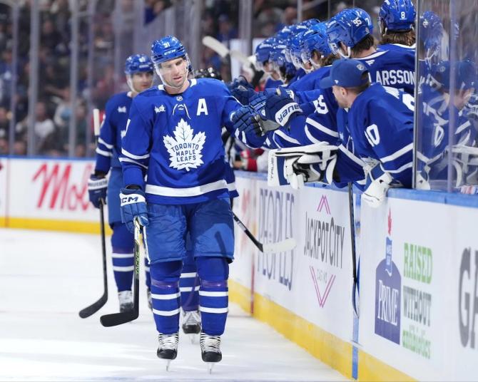 Toronto Maple Leaf John Tavares fist bumps his teammates after scoring a preseason goal.