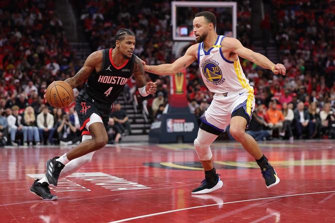 Jalen Green of the Houston Rockets dribbles the ball to the middle of the court against Stephen Curry of the Golden State Warriors.
