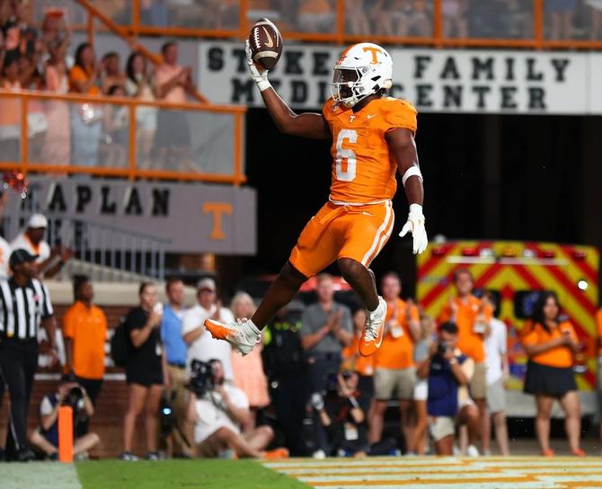 Tennessee football running back Dylan Sampson catches air while celebrating after a touchdown.