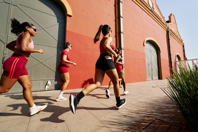 A group of women running next to a building