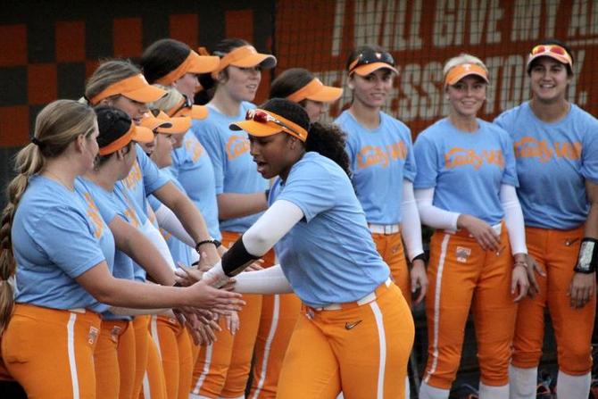 Members of the Tennessee softball team high-five one another.