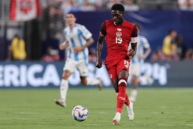 Canadian defender Alphonso Davies plays the ball up the pitch against Argentina.