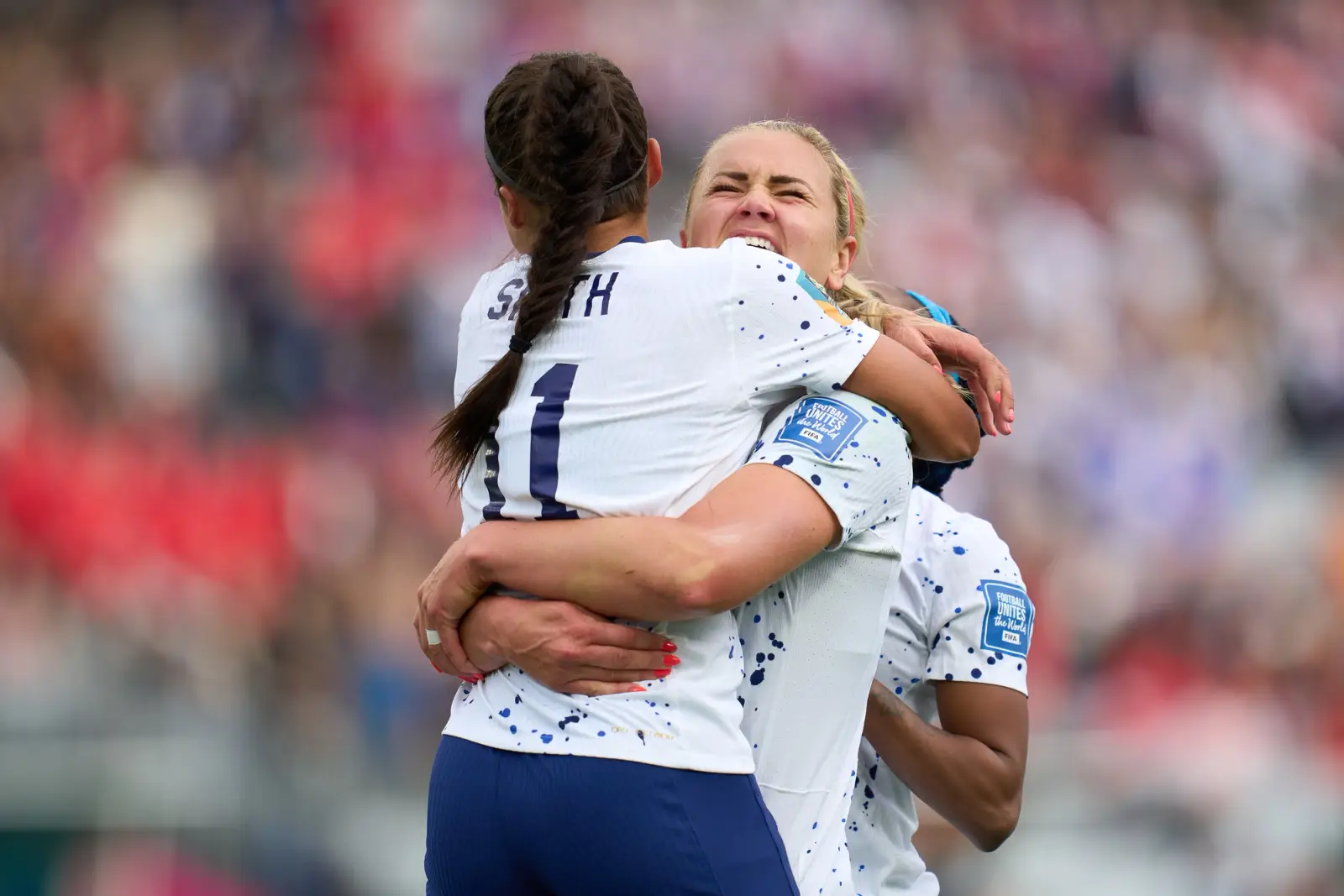 Forward Sophia Smith and midfielder Lindsey Horan embrace on the pitch.