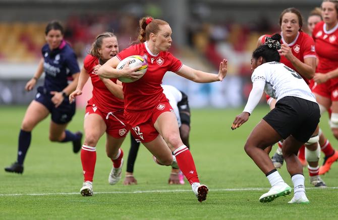 Canadian captain Alex Tessier attempts to stiff arm a Fijian player during group stage action at the Women’s Rugby World Cup.
