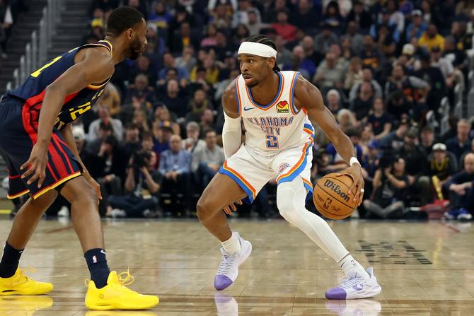 The Oklahoma City Thunder’s Shai Gilgeous-Alexander makes a move on Golden State Warrior Andrew Wiggins.