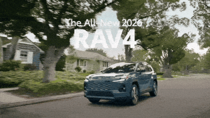 Blue 2026 Toyota RAV4 drives through tree-lined neighbourhood