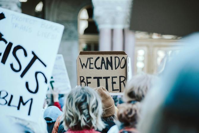 People protesting at a rally holding up signs