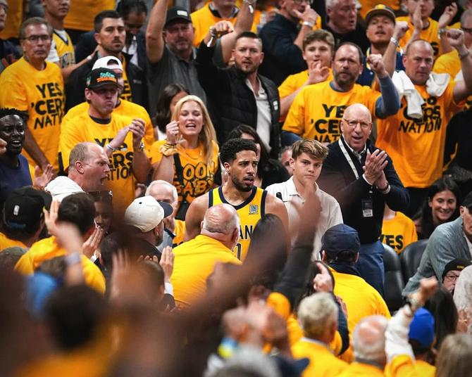 Indiana Pacer Tyrese Haliburton stares down the court while surrounded by Pacers fans.
