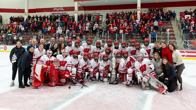 The Wisconsin women’s hockey team poses with their 10th WCHA regular-season championship trophy.
