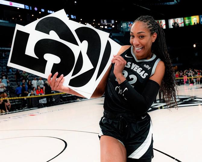 Las Vegas Ace A’ja Wilson holds up cards with the number 5,000 written out in celebration of reaching the 5K-point milestone.