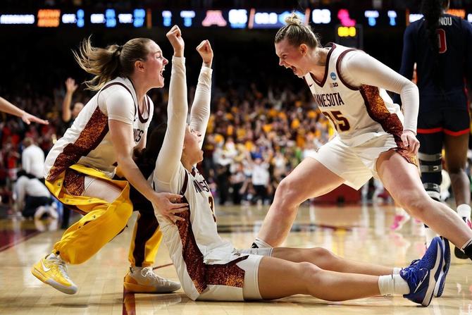 Minnesota’s Amaya Battle raises her hands in celebration as she’s rushed by teammates after her game-winning basket against Ole Miss.