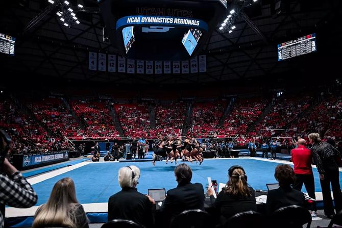 Utah’s women’s gymnastics team leaps into the air mid-huddle during NCAA Regionals.