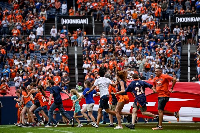Fans running on the field carrying the USA flag