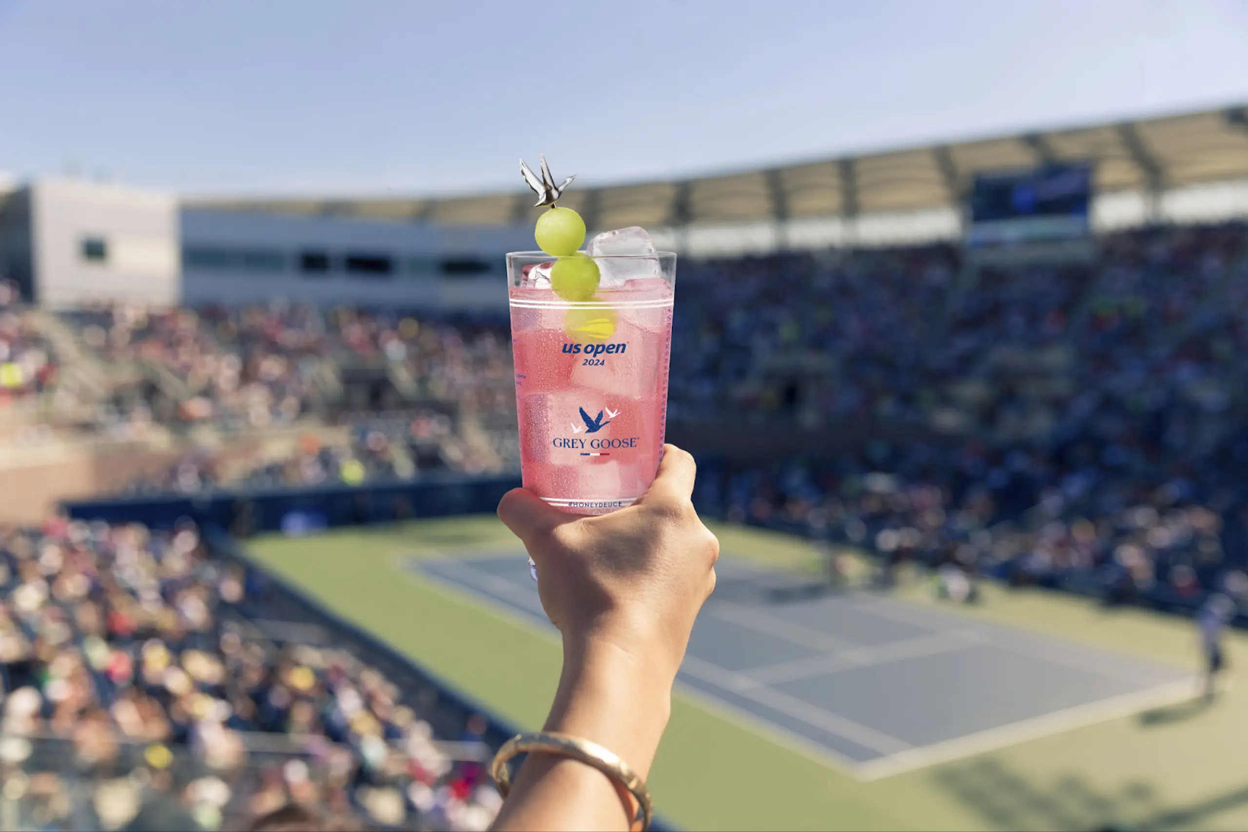 US Open patron holds Honey Deuce in the air