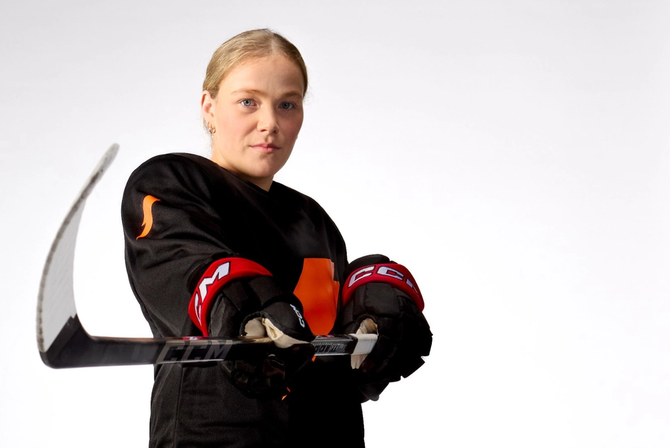 Sarah Fillier posing with a hockey stick