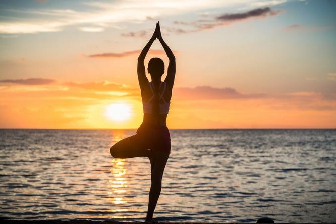 A woman doing yoga on the beach