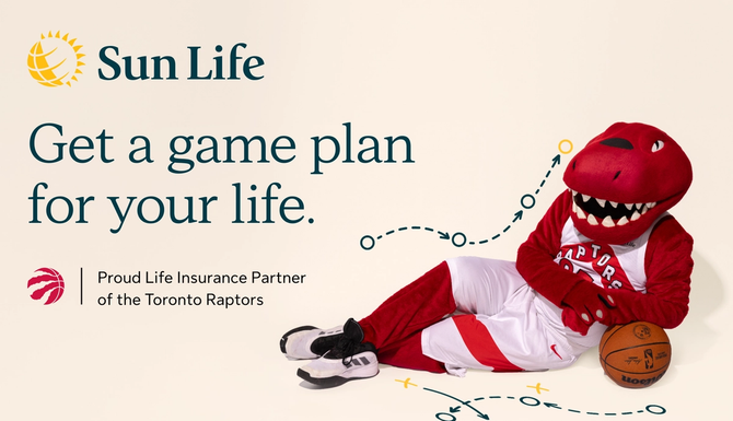 The Toronto Raptors mascot lying on the ground with a basketball