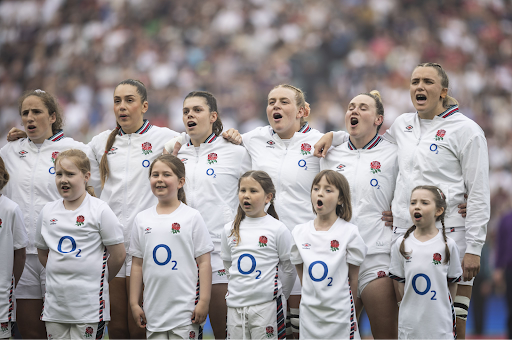 Team England players sing along with young fans before a match.