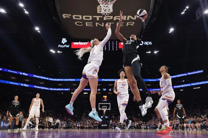 A'ja Wilson #22 of the Las Vegas Aces lays up a shot past Sophie Cunningham #9 of the Phoenix Mercuryduring the first half of the WNBA game