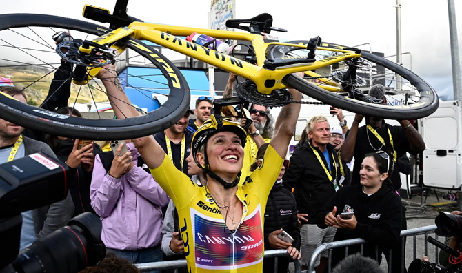 Kasia Niewiadoma holds up her bike after winning the Tour de France Femmes