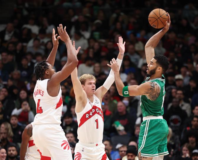 Scottie Barnes (4) of the Toronto Raptors and Gradey Dick (1) guard Jayson Tatum (0) of the Boston Celtics