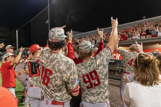 NC State baseball team members celebrate with fans after advancing to the Super Regionals.
