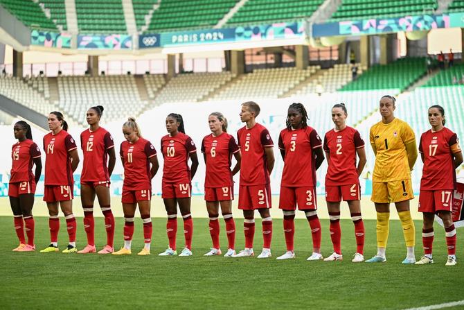 Players of Canada line up before the start of the women's group A football match