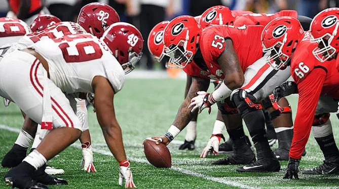The Georgia and Alabama football teams face off at the line of scrimmage.