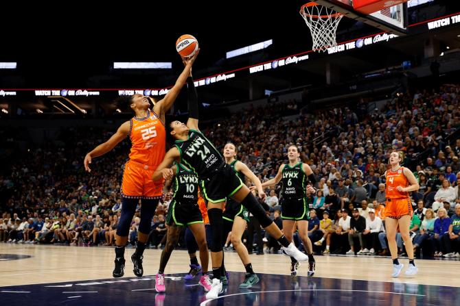 Alyssa Thomas #25 of the Connecticut Sun and Napheesa Collier #24 of the Minnesota Lynx compete for a rebound.