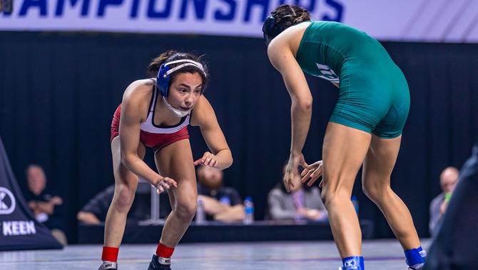 Female collegiate wrestlers compete during a 2022 match.